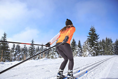 Full length of woman skiing on field against sky