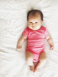 High angle view of baby lying on bed