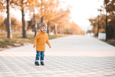 Cute girl sanding on footpath at park