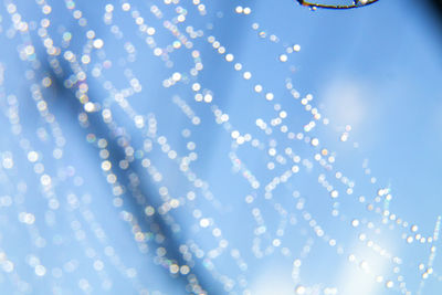 Low angle view of illuminated lights against blue sky