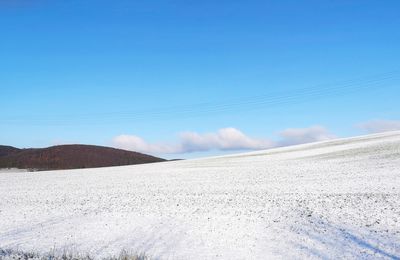 Scenic view of desert against blue sky