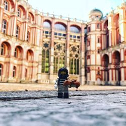 Man photographing on street against building in city