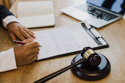 Midsection of man using laptop on table