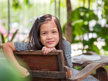 Portrait of smiling girl sitting outdoors