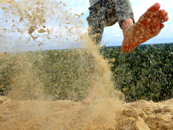 Low section of man jumping in water