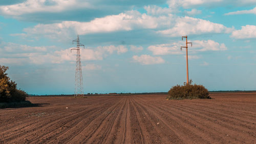 Electricity pylon on field against sky