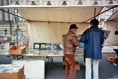 Rear view of men standing by market stall