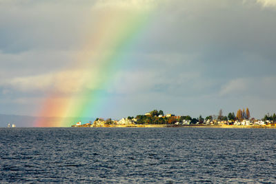 Scenic view of rainbow over sea against sky