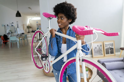 Afro hairstyle woman looking away carrying bicycle