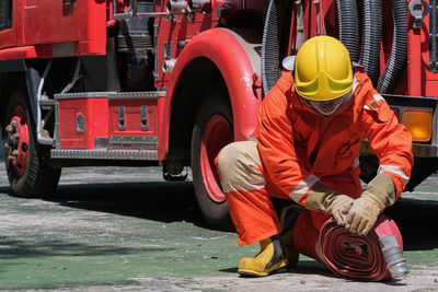 Fire fighter working on road by firetruck