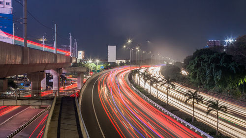 Light trails on road against sky at night