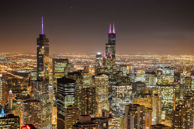 Illuminated cityscape against sky