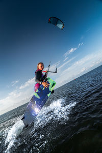 Man surfing in sea against sky
