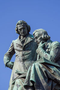 Low angle view of statue against clear blue sky