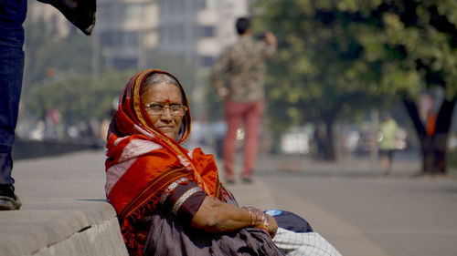 Portrait of woman wearing sari sitting on seat in city