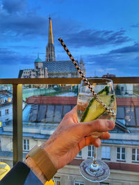 Cropped hand of woman holding drink on table