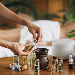 Ayurveda aromatherapy massage, female hand pouring aromatic oil in an essential oil diffuser