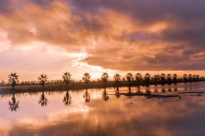 Scenic view of lake against sky at sunset