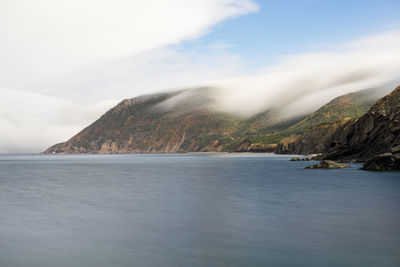 Scenic view of sea and mountains against sky