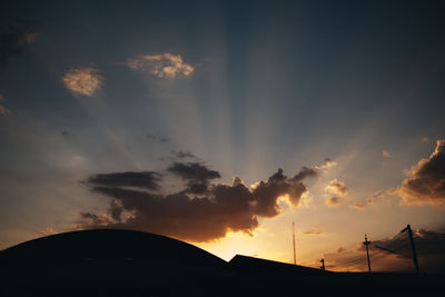 Low angle view of silhouette houses against sky during sunset