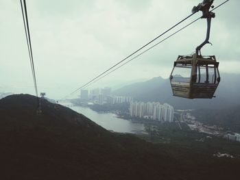 Low angle view of overhead cable cars against sky