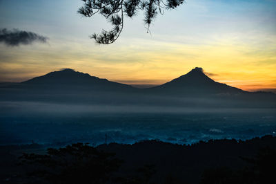 Scenic view of silhouette mountains against sky at sunset