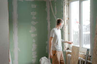 Rear view of woman looking through window