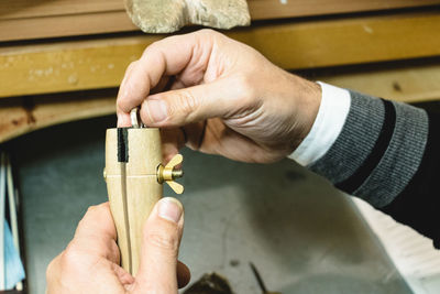 Close-up of man putting ring in container