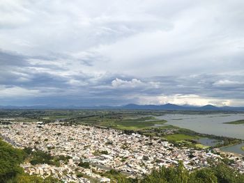 Aerial view of townscape by sea against sky