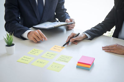 Midsection of business people working on table