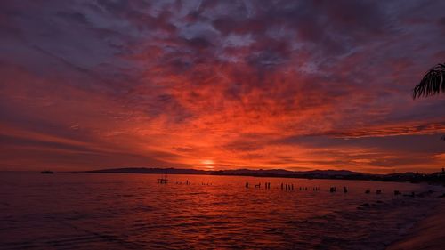 Scenic view of sea against dramatic sky during sunset