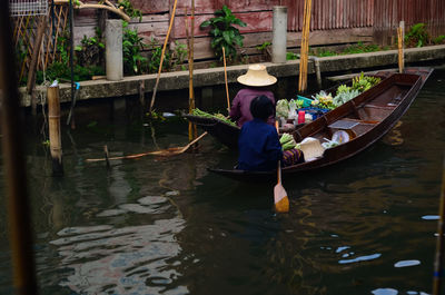 Rear view of woman in boat on canal