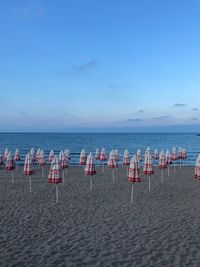 Chairs on beach against sky