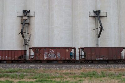 Abandoned freight train against building at shunting yard