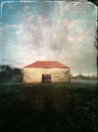 Built structure on field against cloudy sky