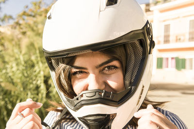 Close-up portrait of smiling teenage girl wearing crash helmet