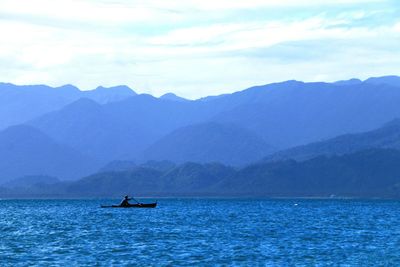 Scenic view of sea and mountains against sky