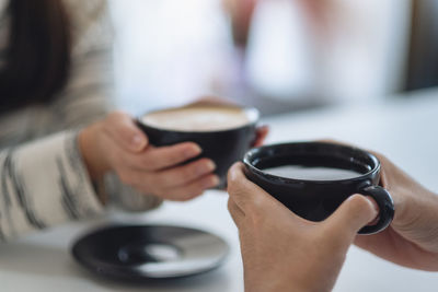 Midsection of woman holding coffee cup