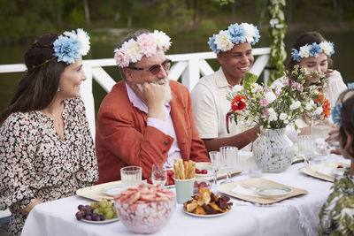 Family having midsummer dinner by lake