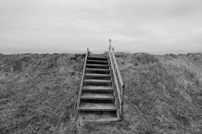 Steps on countryside landscape against sky