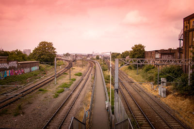 Railroad tracks against sky at sunset