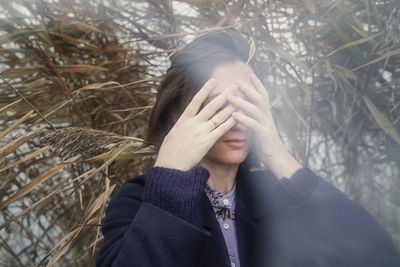 Portrait of a young woman covering face