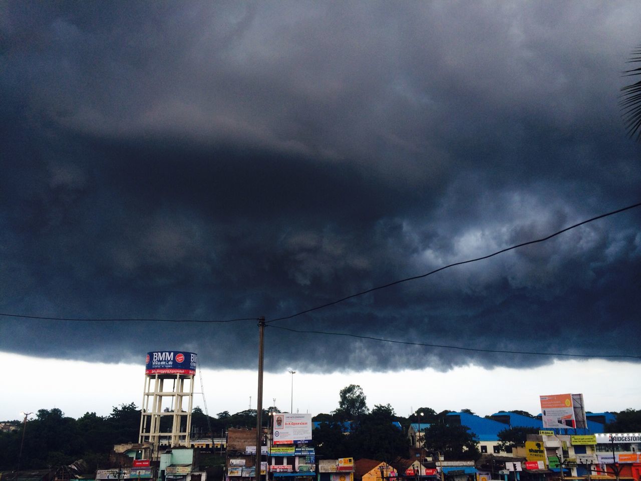 sky, cloud - sky, cloudy, building exterior, built structure, architecture, weather, transportation, car, overcast, land vehicle, mode of transport, cloud, storm cloud, low angle view, city, street, residential building, street light, outdoors