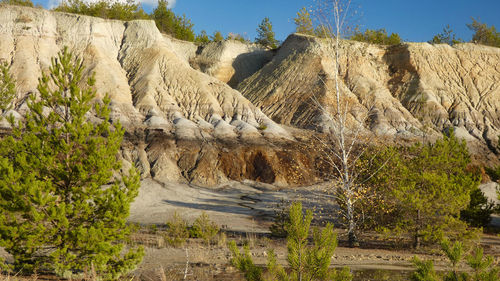 Panoramic view of rock formation amidst trees against sky