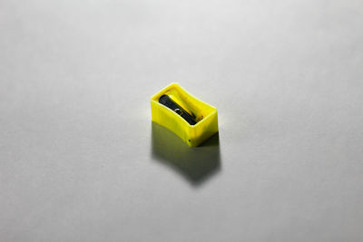 Close-up of yellow toy on table against white background