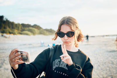 Teenager girl making gesture during video call on smartphone. young woman taking selfie photos