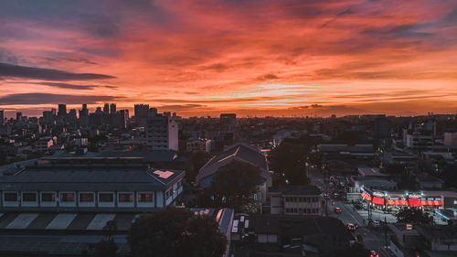 High angle view of buildings against dramatic sky during sunset