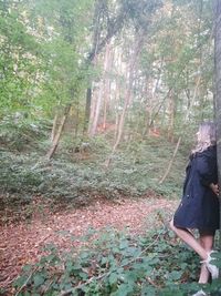 Rear view of woman standing in forest