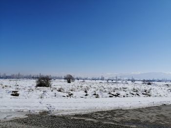 Scenic view of snowcapped landscape against clear blue sky