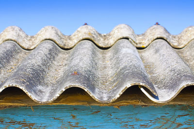 Close-up of metal structure against blue sky